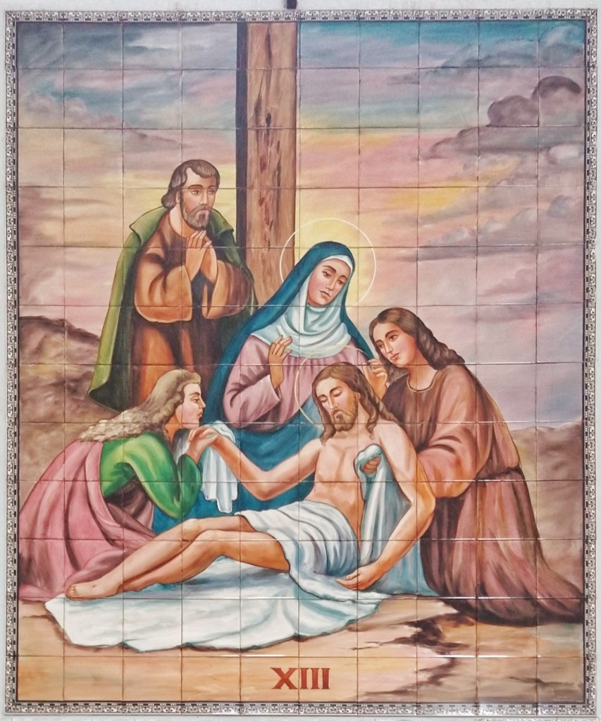 Décima terceira Estação da Via Sacra da Igreja São Sebastião, localizada em Barbacena, MG, feita pelo Atelier Sarasá, em 1984, pintada em  azulejo. Na imagem contemplamos Jesus sendo descido da cruz e sendo entregue a sua mãe Maria. Essa cena também é conhecida como Pietá.